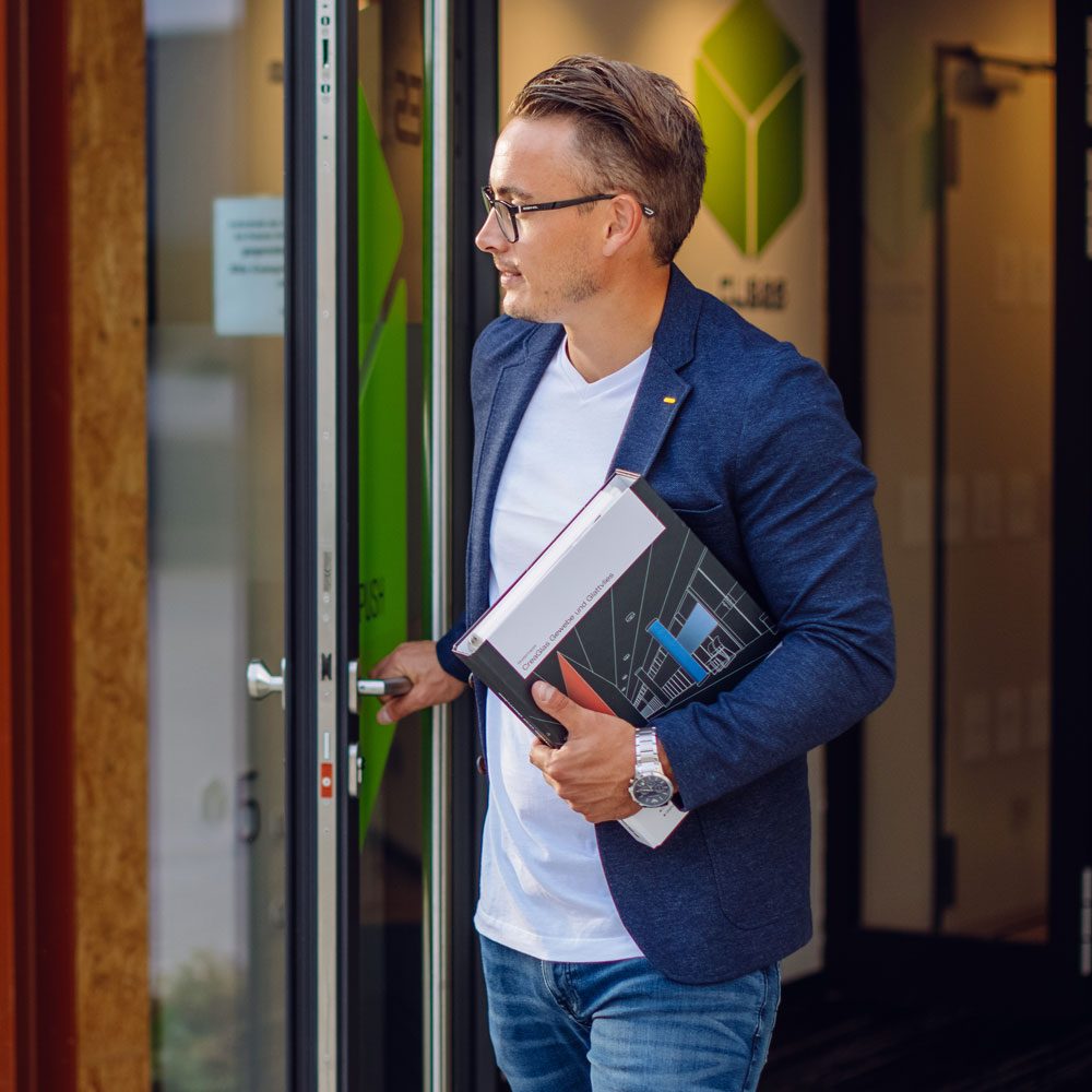 Immobilienberater von Nobel & Company betritt das Büro mit Unterlagen