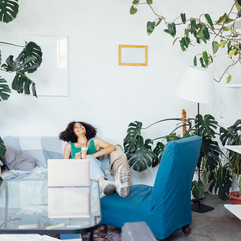 Frau entspannt in einer modern eingerichteten Mietwohnung